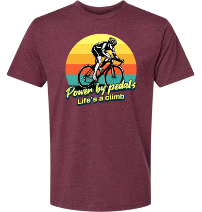 Man riding road bicycle with sunset behind and the words power by pedals, life's a climb front and center