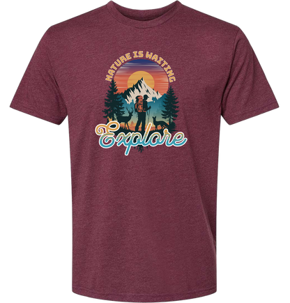 A Heathermaroon crewneck t-shirt with a graphic print of a mountain and the words 'Nature Is Waiting Explore' on it.